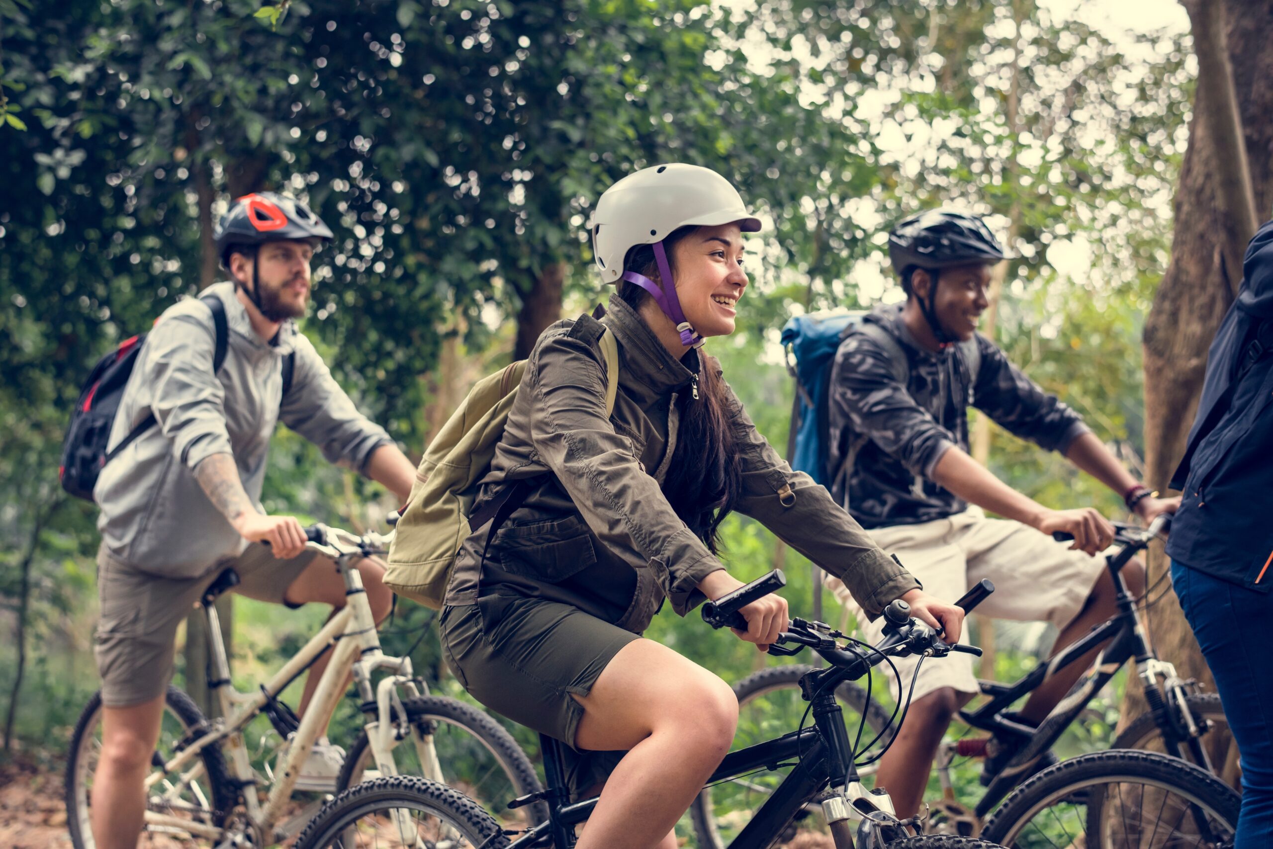 Group of friends ride mountain bike in the forest together